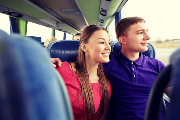 happy teenage couple or passengers in travel bus - 写真・画像