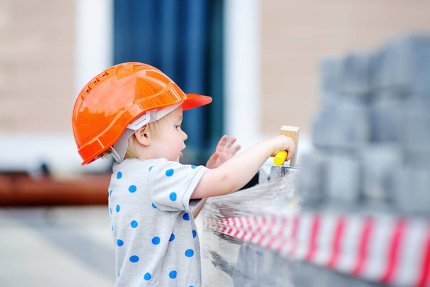 Little builder in hardhats with hammer working outdoors - Photo, Image