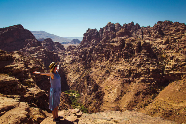 Wolność dla podróżujących kobiety stojącej z podniesionymi rękami, ciesząc się niesamowity krajobraz górski. Widok z Petra, Wadi Araba pustyni. Hipster młodej dziewczyny kochają podróże, wolność. Letnie wakacje. Miejsce - Zdjęcie, obraz