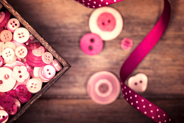レトロなピンクのボタンとリボン - 写真・画像