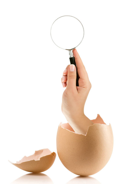 Mano con huevo roto aislado sobre fondo blanco
 - Foto, Imagen