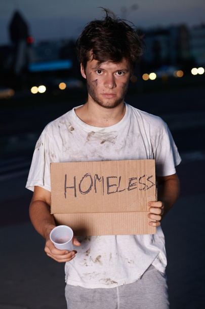 Un senzatetto che chiede aiuto, seduto su una strada
 - Foto, immagini