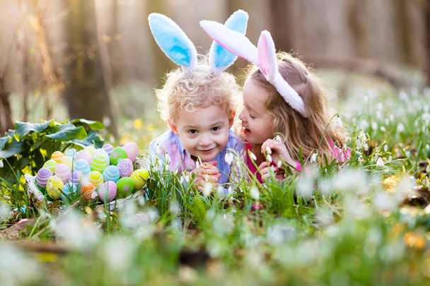 Kids on Easter egg hunt in blooming spring garden - Photo, Image