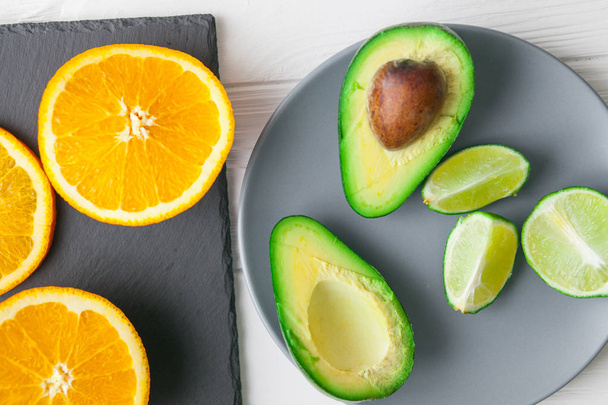 avocado , orange and lime on stone board - Фото, зображення