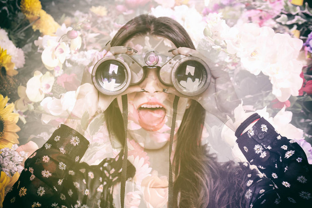 Double exposure of surprised girl looking through binoculars and flowers - Φωτογραφία, εικόνα