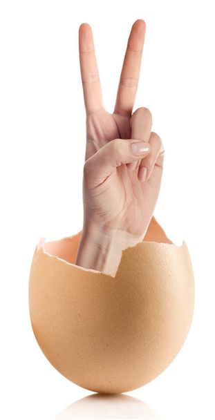 Mano con huevo roto aislado sobre fondo blanco
 - Foto, Imagen