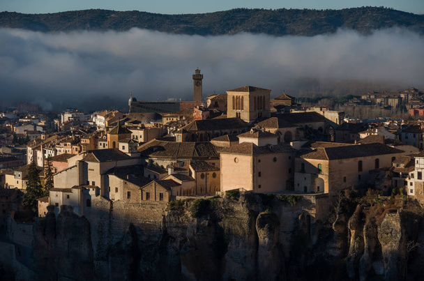 View to houses of Cuenca old town with morning fog at background. Medieval city, built on the steep sides of a mountain. Cuenca, Spain - Photo, Image