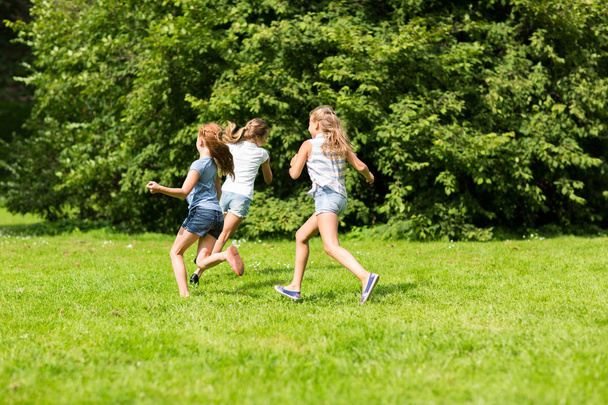 group of happy kids or friends playing outdoors - Foto, afbeelding