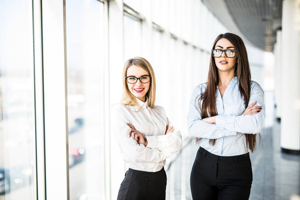 Young business ladies in office hall over panoramic windows. - Foto, Bild
