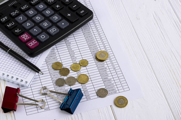 calculadora, moedas, caneta, acessórios de escritório e papel financeiro sobre
 - Foto, Imagem