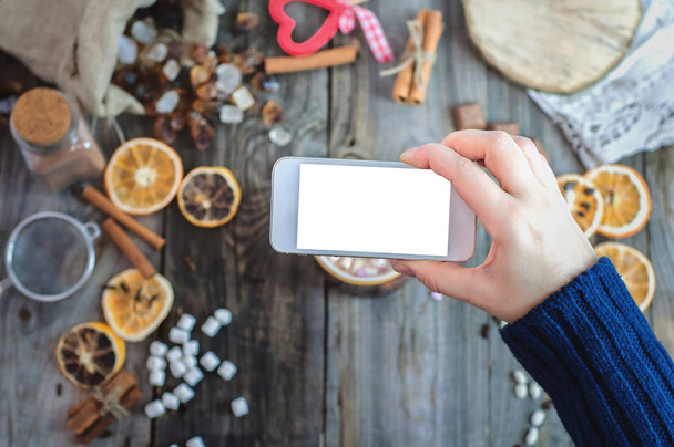Main tenant un smartphone sur une table blanche avec de la nourriture
 - Photo, image