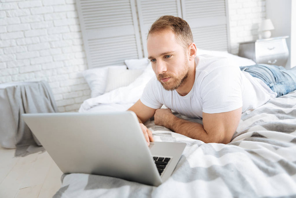 Handsome bearded man surfing the Internet at home - Fotografie, Obrázek