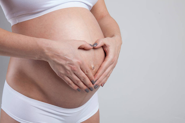Vientre de una mujer embarazada aislada sobre fondo blanco
 - Foto, imagen