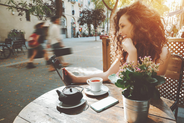 Σγουρό κορίτσι στην καφετέρια του δρόμου - Φωτογραφία, εικόνα