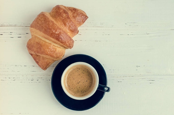 Cup of espresso coffee and fresh baked croissant - Photo, image