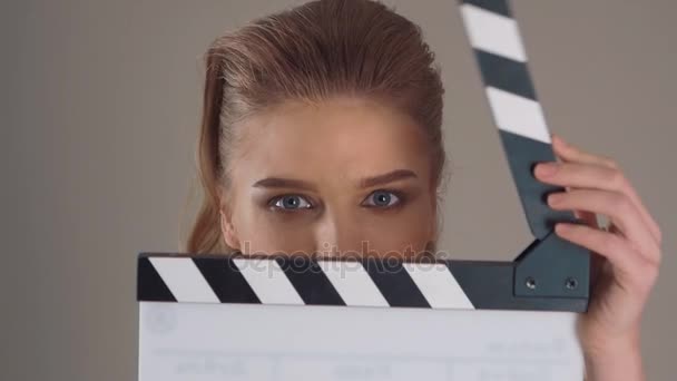 Filming. Close up of Beautiful young woman with clapperboard in hands - Séquence, vidéo