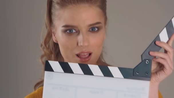Filming. Close up of Beautiful young woman with clapperboard in hands - Filmagem, Vídeo