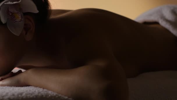 Mädchen ruht sich nach einer Massage im schummrigen Licht aus. Studio - Filmmaterial, Video