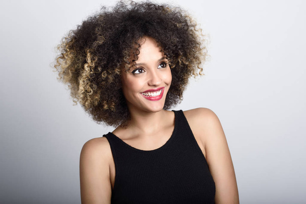 Joven mujer negra con peinado afro sonriendo
 - Foto, Imagen