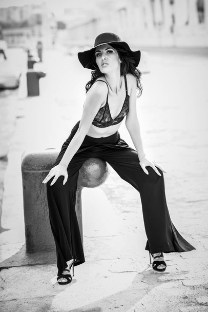 Brunette woman wearing black bra and trousers - Photo, Image
