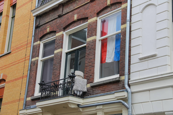 Facade of old building with national flag behind window in Utrec - Foto, imagen