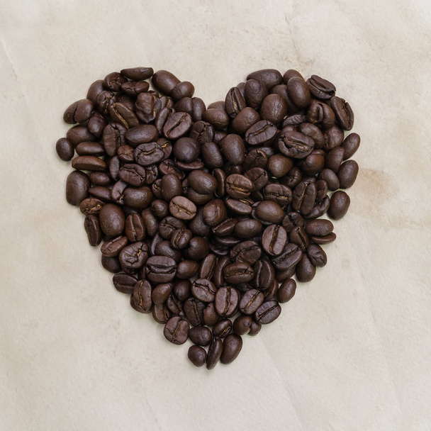 Серце у формі смажених кавових зерен на старовинному паперовому фоні
. - Фото, зображення