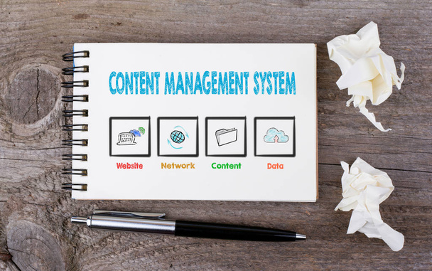 Content Management System. Notizbuch und Stift auf dem Holzgrund - Foto, Bild