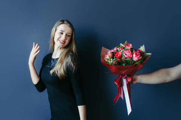 Cute girl getting bouquet of red tulips. Boyfriend giving tulips. - Foto, afbeelding