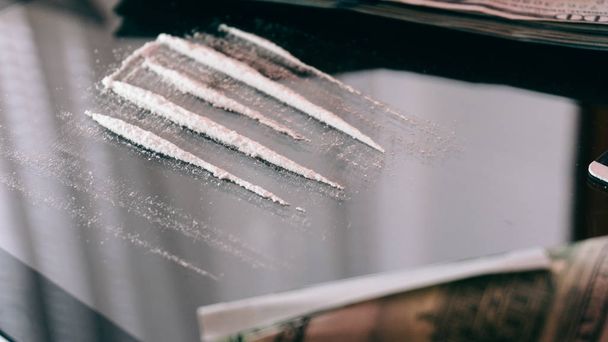 Cocaïne gesnurkt via warmgewalste 100 Dollar biljet. levensstijl van een drugsverslaafde  - Foto, afbeelding