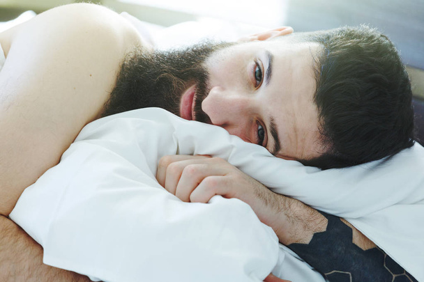 sleepy bearded man lying in bed - Φωτογραφία, εικόνα