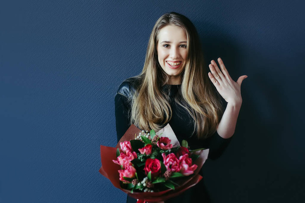 Cute girl with bouquet of red tulips. - 写真・画像