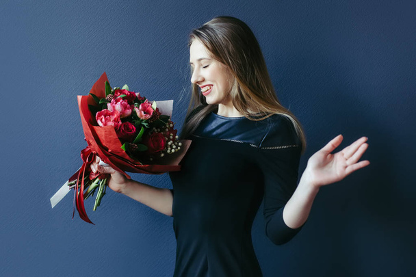 Cute girl with bouquet of red tulips. - Фото, зображення