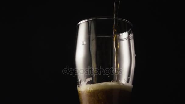 Dark beer is poured into a glass camera moves from top to bottom - Materiał filmowy, wideo
