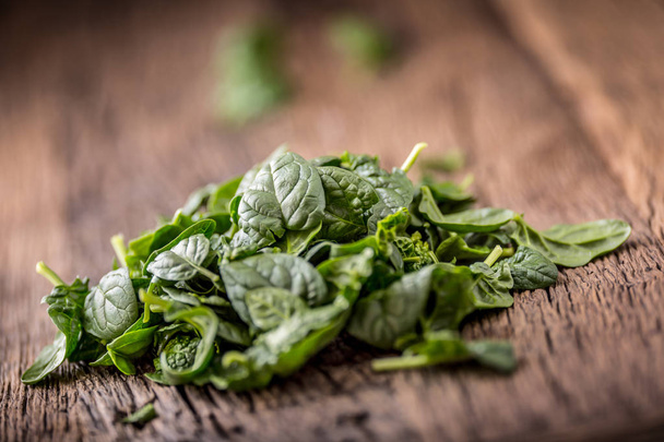 Spinach leaves.Fresh spinach leaves in retro bowl on oak wood board. Selective focus - Foto, Bild