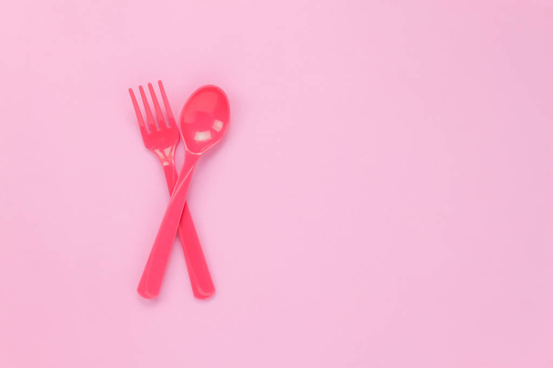 Cuchara de plástico colorida vista superior sobre fondo de mesa rosa
  - Foto, Imagen