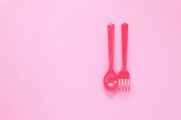 Το Top view πολύχρωμο πλαστικό κουτάλι σε φόντο Ροζέ πίνακα  - Φωτογραφία, εικόνα
