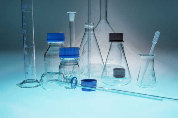 Sinisellä pöydällä olevat lasilaboratoriolaitteet
 - Valokuva, kuva