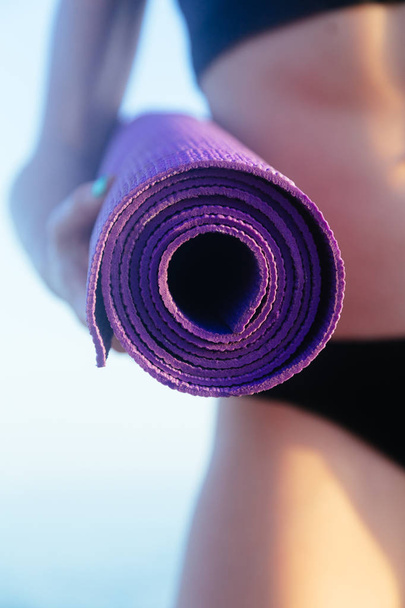 Donna sportiva per il tempo libero con perfetto corpo in possesso di tappetino yoga. Concetto vita sanitaria
. - Foto, immagini