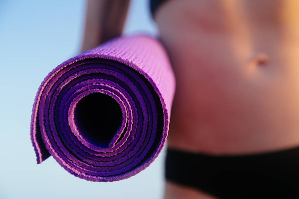 Donna sportiva per il tempo libero con perfetto corpo in possesso di tappetino yoga. Concetto vita sanitaria
. - Foto, immagini