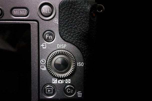 Einstellrad an einer DSLR-Kamera, spiegellos, Nahaufnahme isoliert auf schwarzem Hintergrund - Foto, Bild