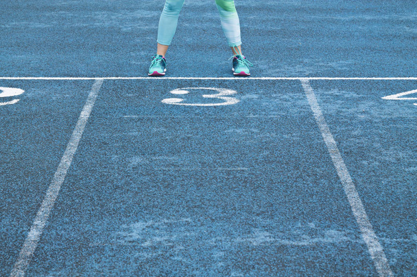 woman legs in leggings and running shoes on running track - 写真・画像