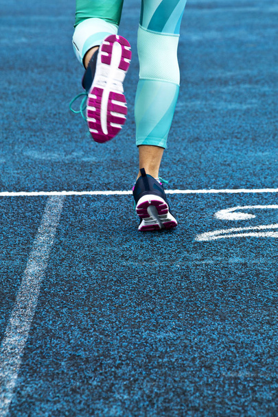 woman running in blue running track - Fotografie, Obrázek