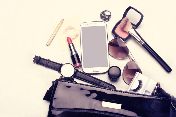 Flat lay of black woman bag open up with cosmetics and accessories - Foto, afbeelding