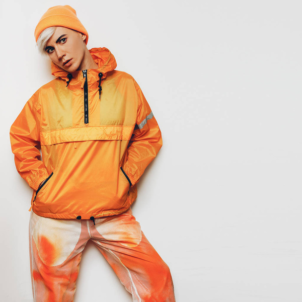 trendiges urbanes Outfit Tomboy Mädchen in leuchtend orangefarbener Sportbekleidung - Foto, Bild