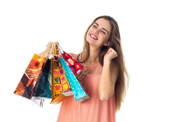 cute smiling girl closed her eyes and holds different colored bags isolated on white background - Photo, image