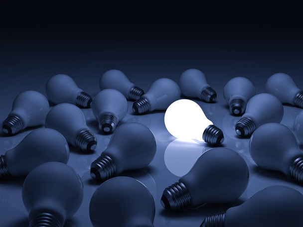 Une ampoule lumineuse se détachant des ampoules incandescentes non éclairées avec réflexion sur fond bleu, individualité et différents concepts d'idées créatives
 - Photo, image
