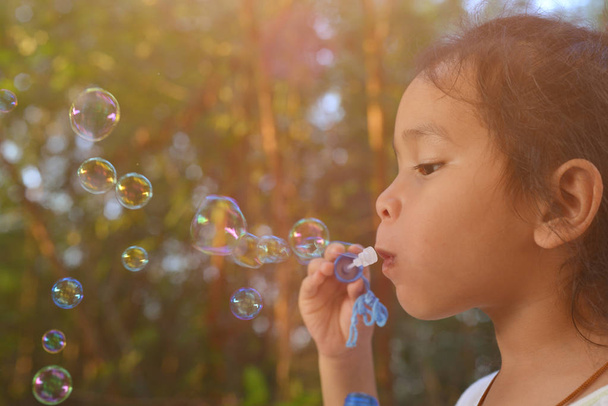 Kind pustet Seifenblasen - Foto, Bild