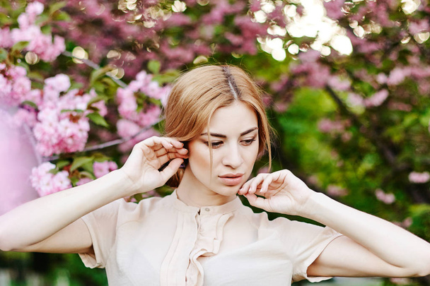 Porträt von schönen Mädchen auf Kirschblütenhintergrund - Foto, Bild