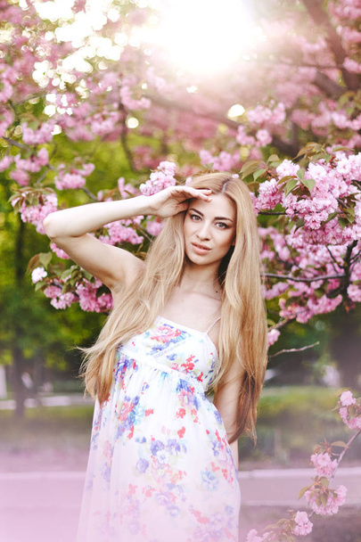 Portrait of beautiful girl on cherry blossom background - Foto, Imagem