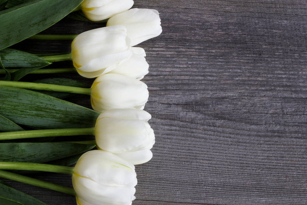 Ramo de flores de tulipán blanco en la vieja mesa de madera. Pascua.Día de las Madres
.   - Foto, Imagen